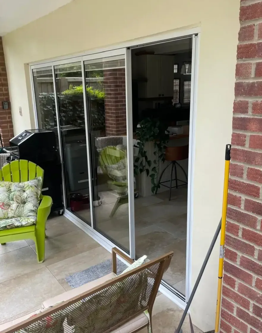 slimline internal slide and turn doors between a living room and conservatory, with one door panel open as a traffic door